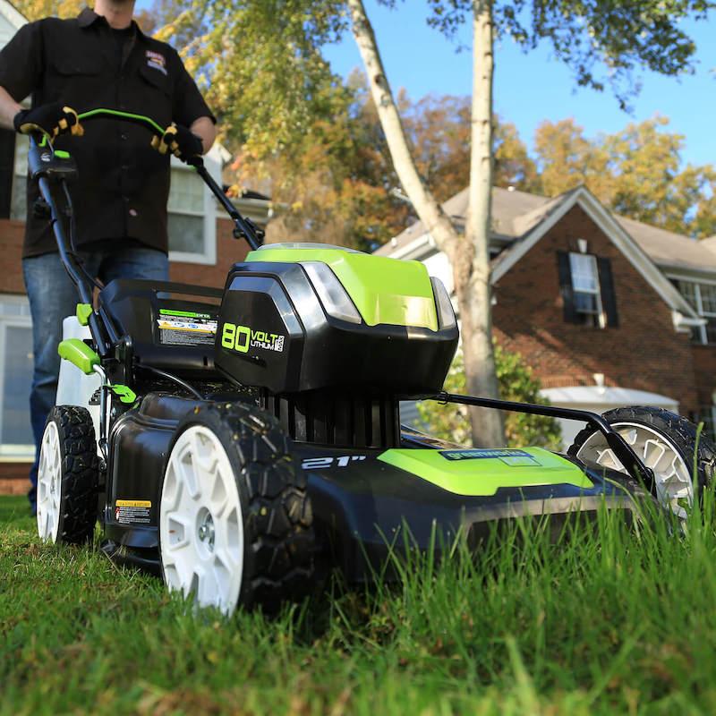 Photo of a person pushing a Greenworks lawnmower