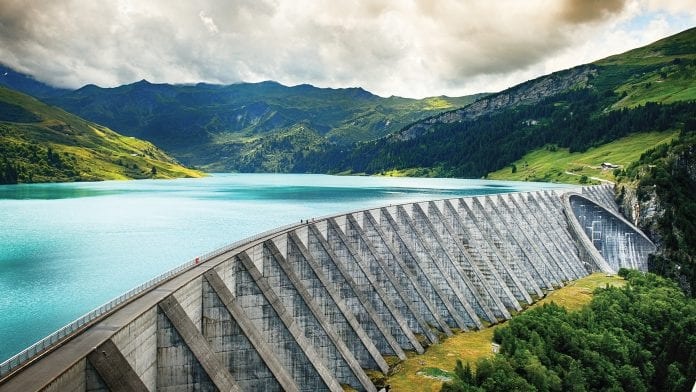 A large dam in front of mountains