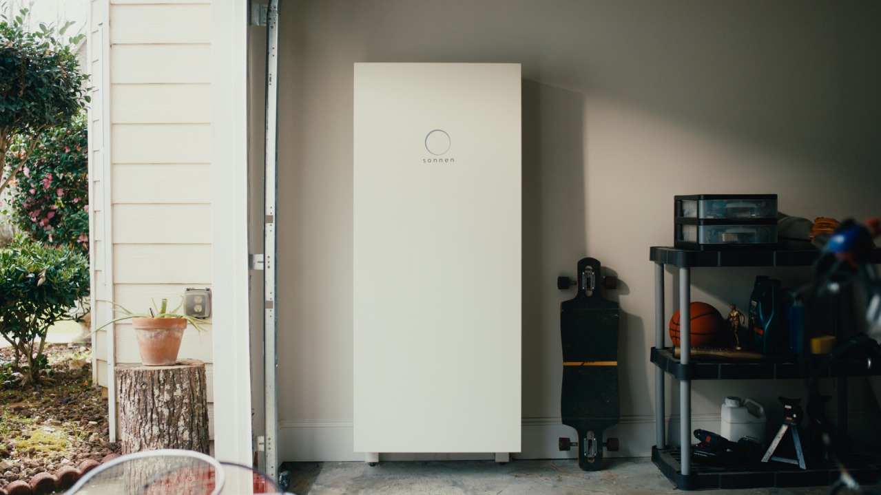 Photo of a sonnenCore battery in a garage next to a skateboard and other sporting goods