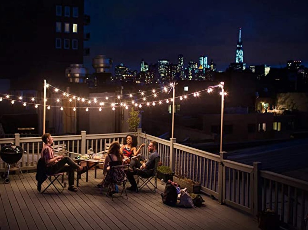 Sunlitec solar string lights lighting up an outdoor gathering on a balcony