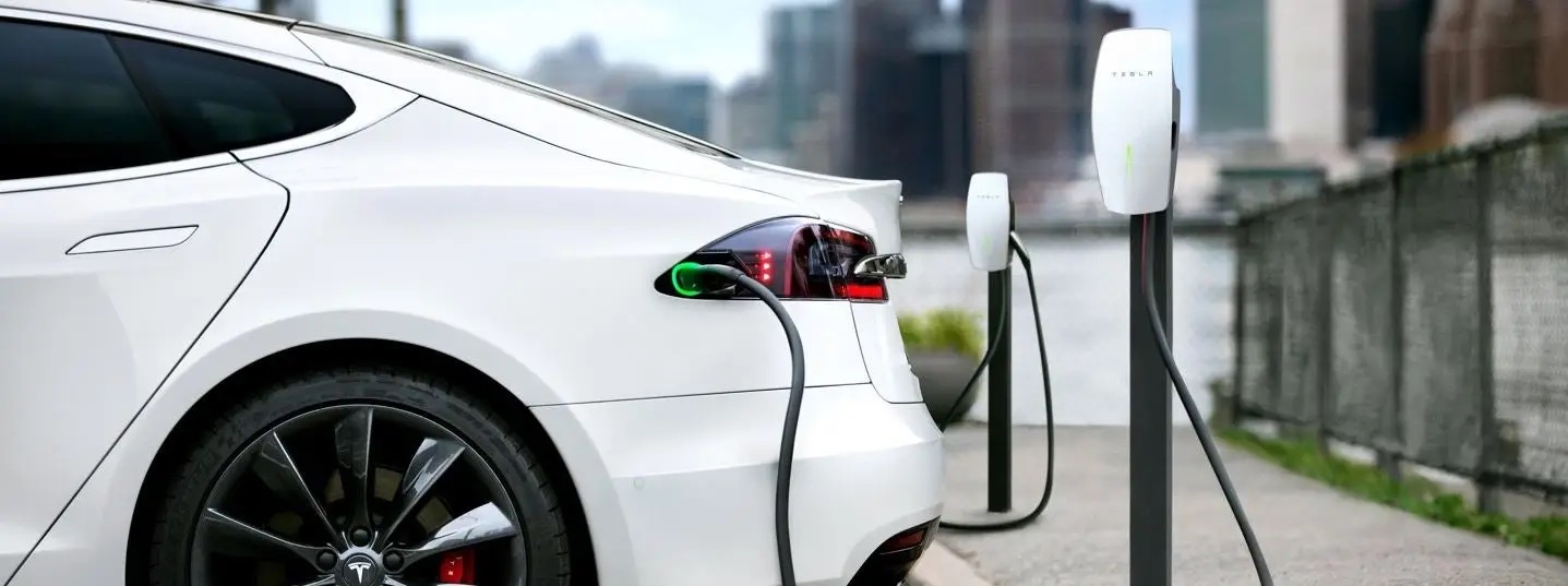 tesla ev charging at a station outdoors