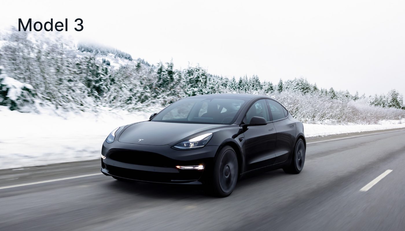 A black Tesla Model 3 driving in a snowy area